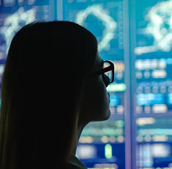 A person looking at a large digital screen displaying data.